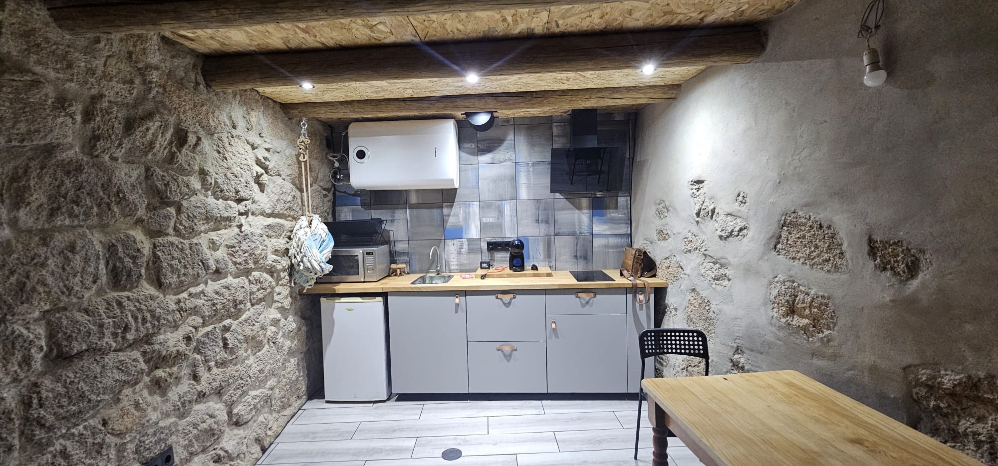 Cozinha integrada entre paredes de pedra