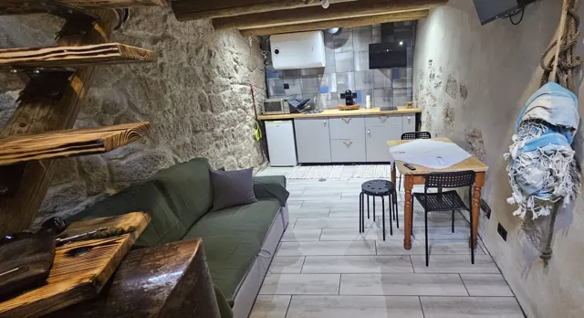 Sala e cozinha, entre paredes de pedra.