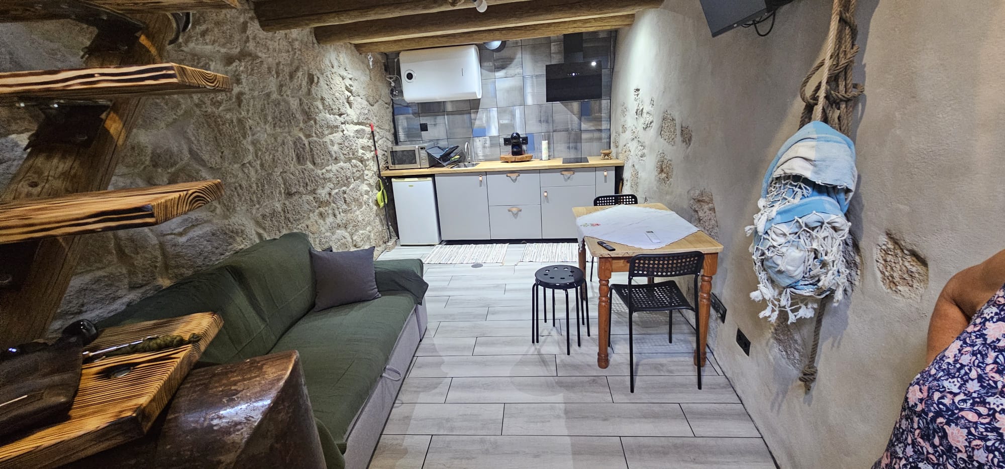 Interior da casa com paredes de pedra e estrutura de madeira